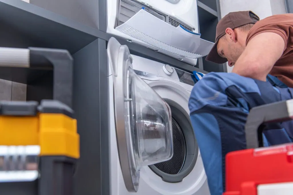 Appliance repairman fixing a washing machine