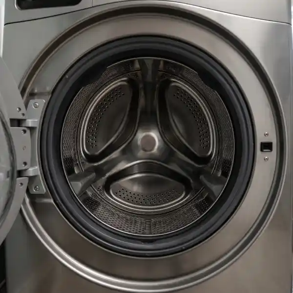 Empty and completely dry stainless steel interior of a washing machine drum that is failing to fill.